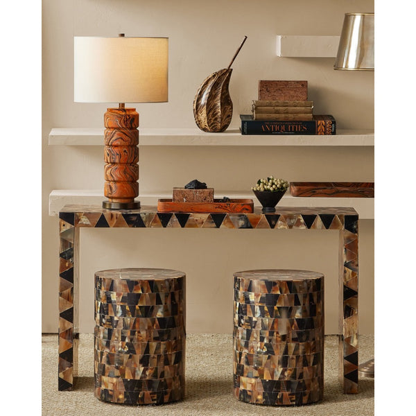 Decorative console table with patterned legs and stools in a room setting.