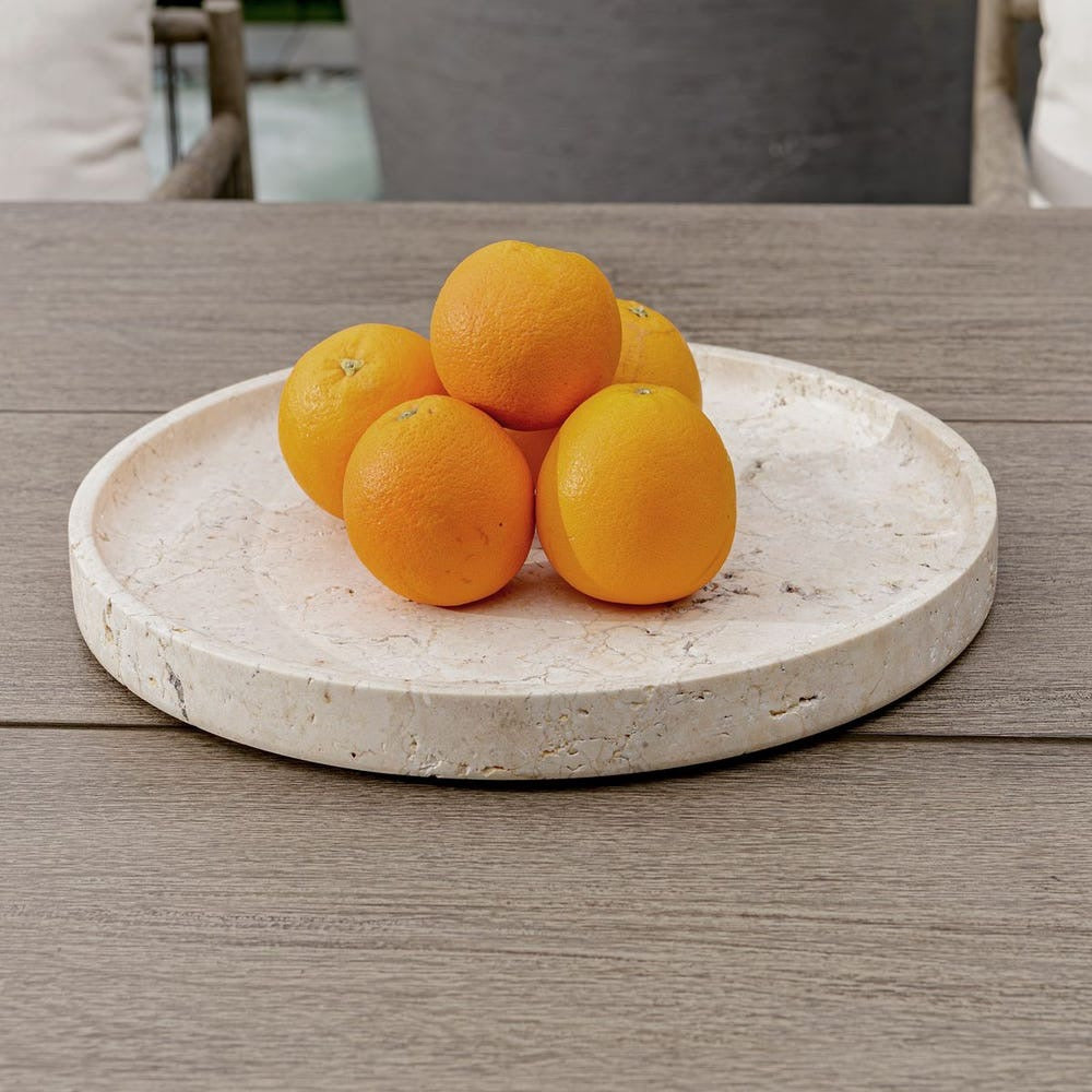 Oranges on a stone tray on a wooden table