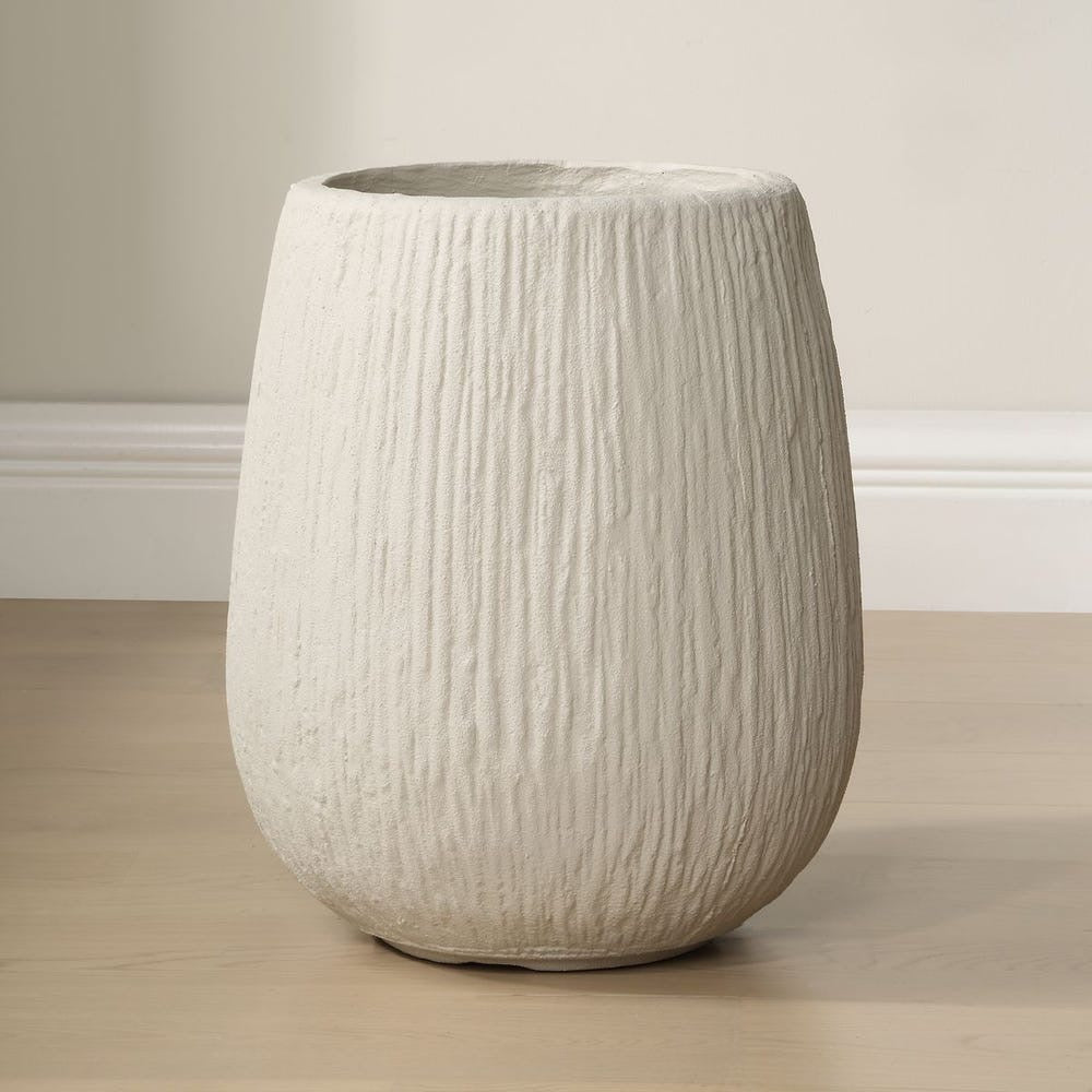 Textured planter on a wooden floor with a neutral background