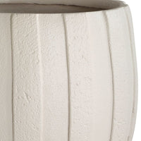 Close-up of a textured white planter with concentric striped patterns.