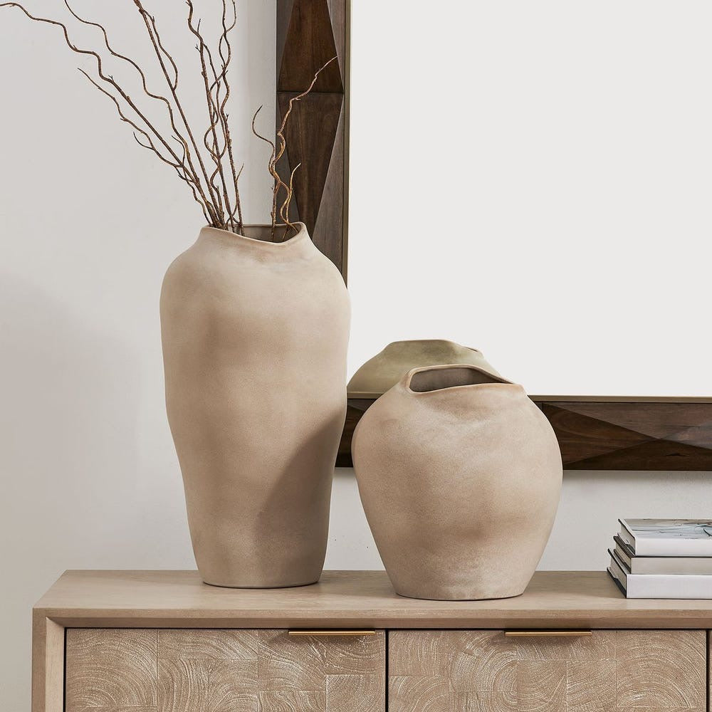 Two beige vases on a wooden cabinet with a neutral background