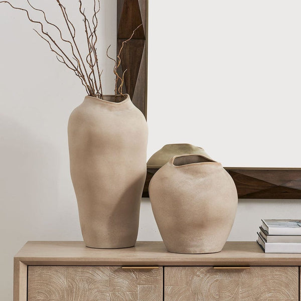 Two beige vases on a wooden cabinet with a neutral background