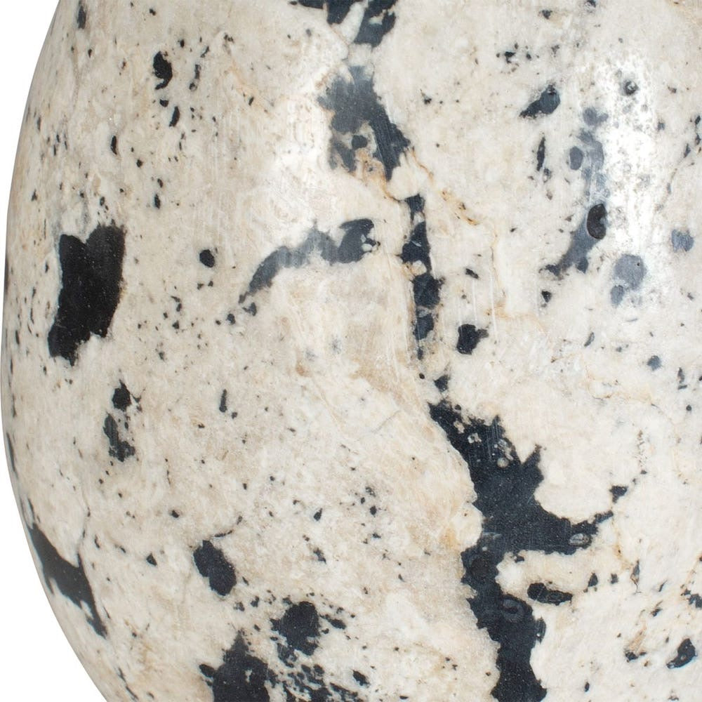 Close-up of a speckled stone with black and gray patterns on a white background