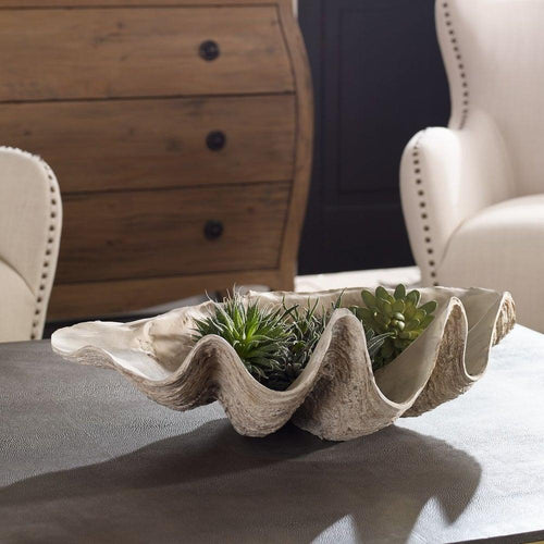 The Uttermost Clam Shell Bowl with succulents brings coastal charm to your table, paired with cream chairs and wood decor.