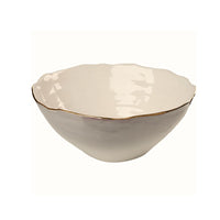 Beige ceramic bowl with gold rim on a white background