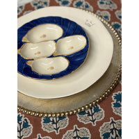 Decorative plate with oyster shells on a patterned tablecloth