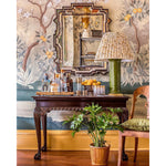Mirror Home's Heavy Beveled Mirror - Brown Antiqued Glass, above a wooden table with bottles, a lamp, and a potted plant.