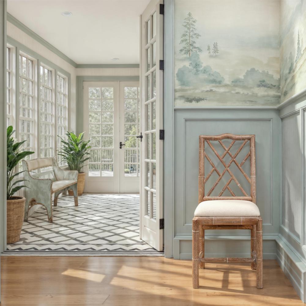 Decorative interior with a wooden chair, plants, and a French door leading to a patio.