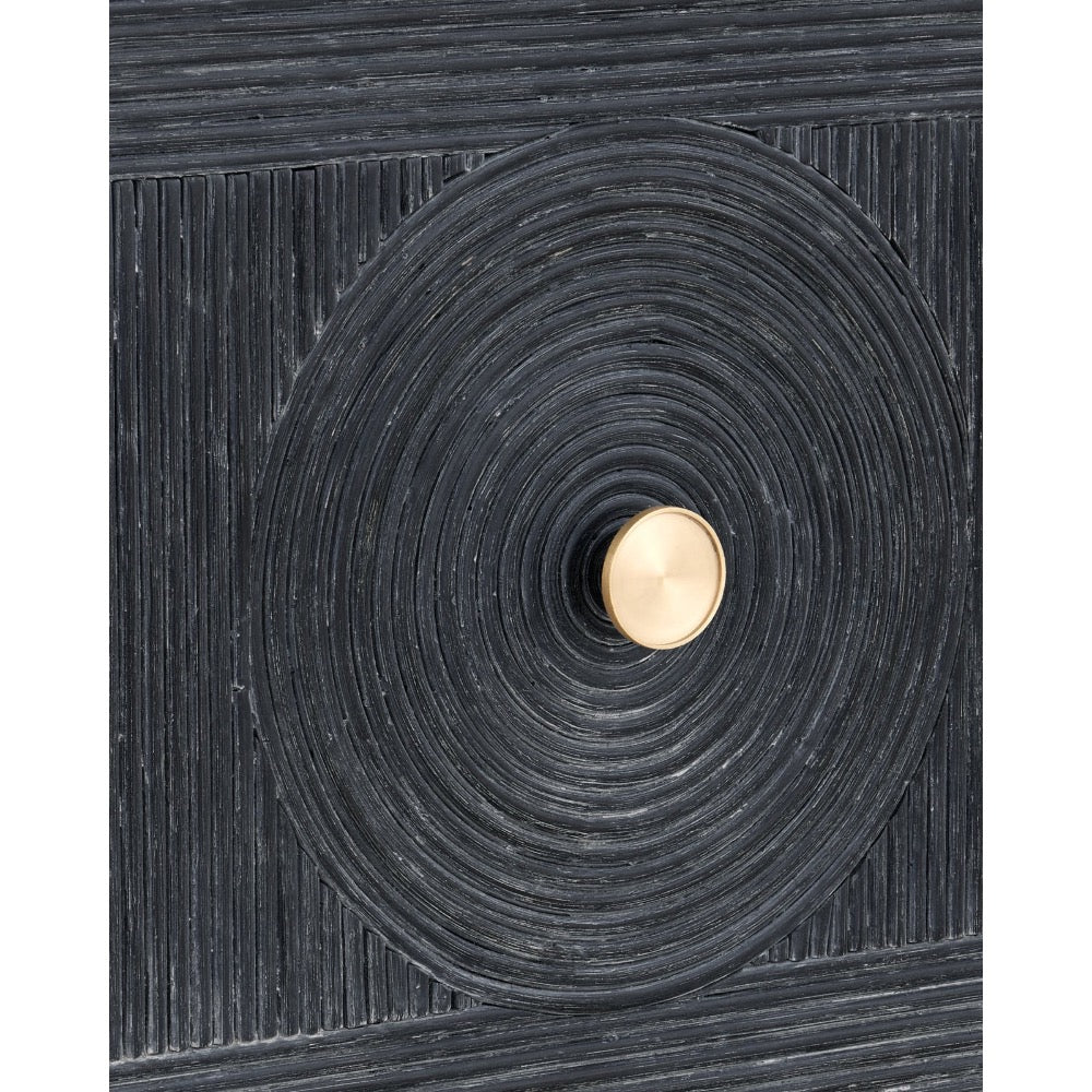 A close-up of a dark charcoal textured cabinet or door featuring a large circular concentric design with a central round gold knob.