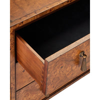 Close-up of a wooden drawer with a burl wood grain finish, partially open to reveal a black interior, featuring a brass pull handle with a tassel detail.