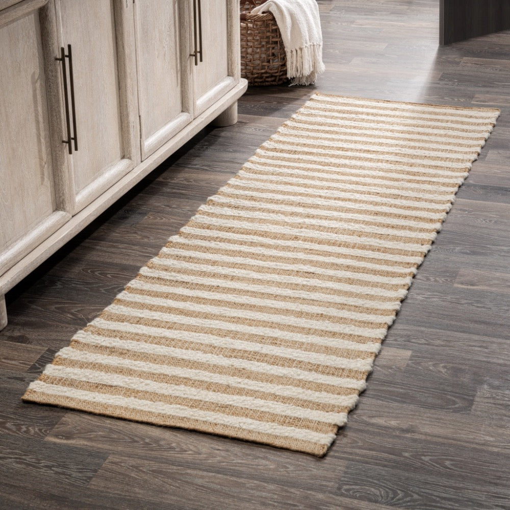 Striped rug on a wooden floor next to a cabinet