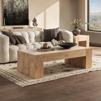Modern living room with a wooden coffee table, sofa, and decorative items.