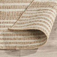 Textured beige and brown striped rug on a wooden floor