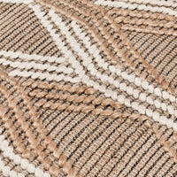 Close-up of a woven rug with a geometric chevron pattern in natural beige, tan, and off-white.