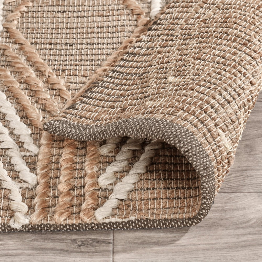 Close-up of a woven mat with natural fibers on a wooden floor.