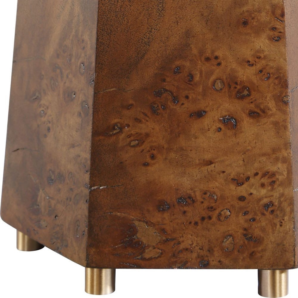 Close-up of a brown wooden lamp base with a burl pattern and brass legs.