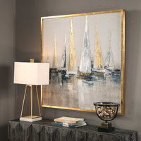 Decorative table with a lamp, books, and a decorative bowl, featuring a large abstract painting of sailboats on a wall.