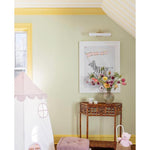 yellow painted girls bedroom with rattan demi lune table
