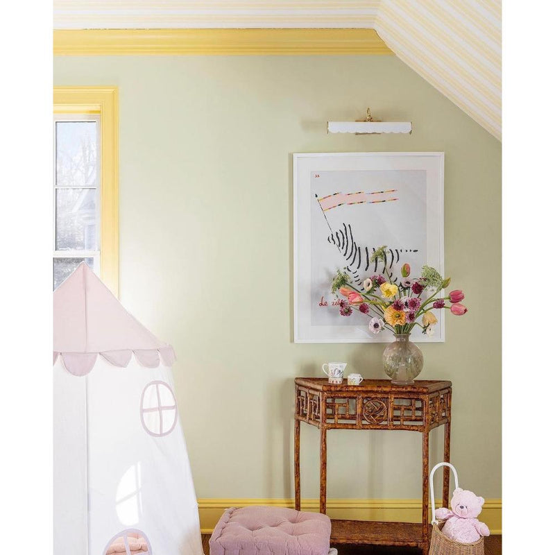 yellow painted girls bedroom with rattan demi lune table