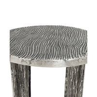 A close-up of a stool with a textured, wavy wood-grain patterned seat and distressed, weathered legs on a plain white background.