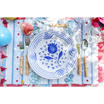 Abigails Casa Nuno Blue Pomegranate Dinner Plates (set of 2) with bamboo cutlery on a vibrant, patterned tablecloth.