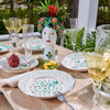 A table set with Abigails Casa Nuno Green Flower Dinner Plates, yellow glasses, and a floral ceramic head vase centerpiece.