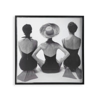 Framed black and white art print of three women sitting with their backs to the viewer.