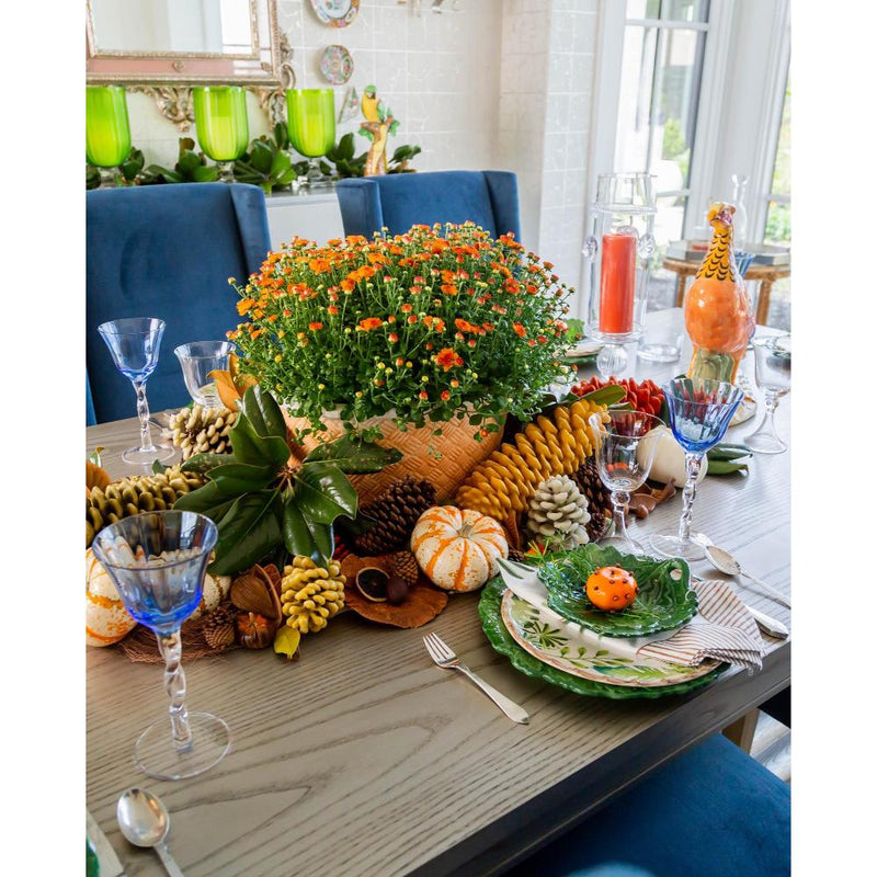 Decorative table setting with fall-themed centerpieces and colorful glasses.
