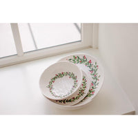 Set of ceramic plates with floral design on a windowsill
