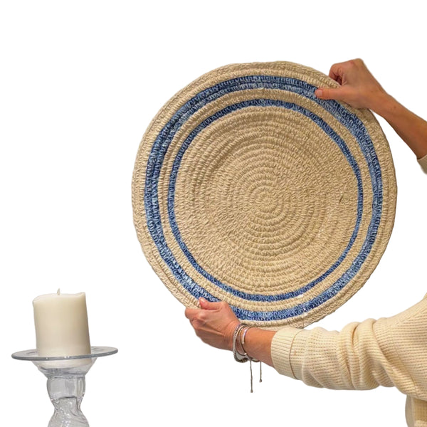 Someone holds Abigails' Ceramic Aster Basket Plate; a white candle and ceramic centerpiece are nearby.