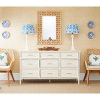 rattan wall mirror over white bureau 