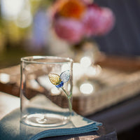 Abigails Twig and Flowers Icon Cocktail Glasses (set of 4) displayed outdoors on a napkin among flowers.