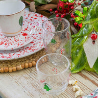 Decorative glassware with Christmas-themed designs on a festive table setting.