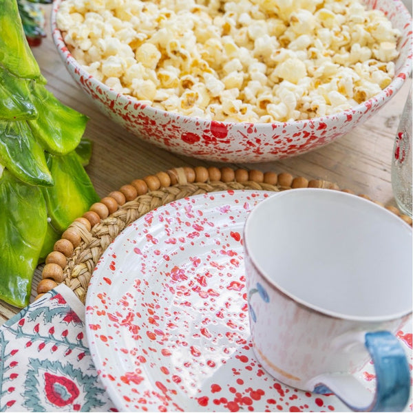 Bowl of popcorn on a table with a mug and decorative items.
