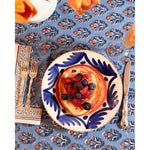 Decorative plate with pancakes and berries on a patterned tablecloth