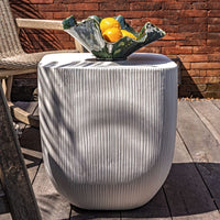 Decorative outdoor side table with a textured surface, placed on a wooden deck.