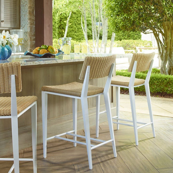 Outdoor setting with bar stools and a table on a wooden deck.