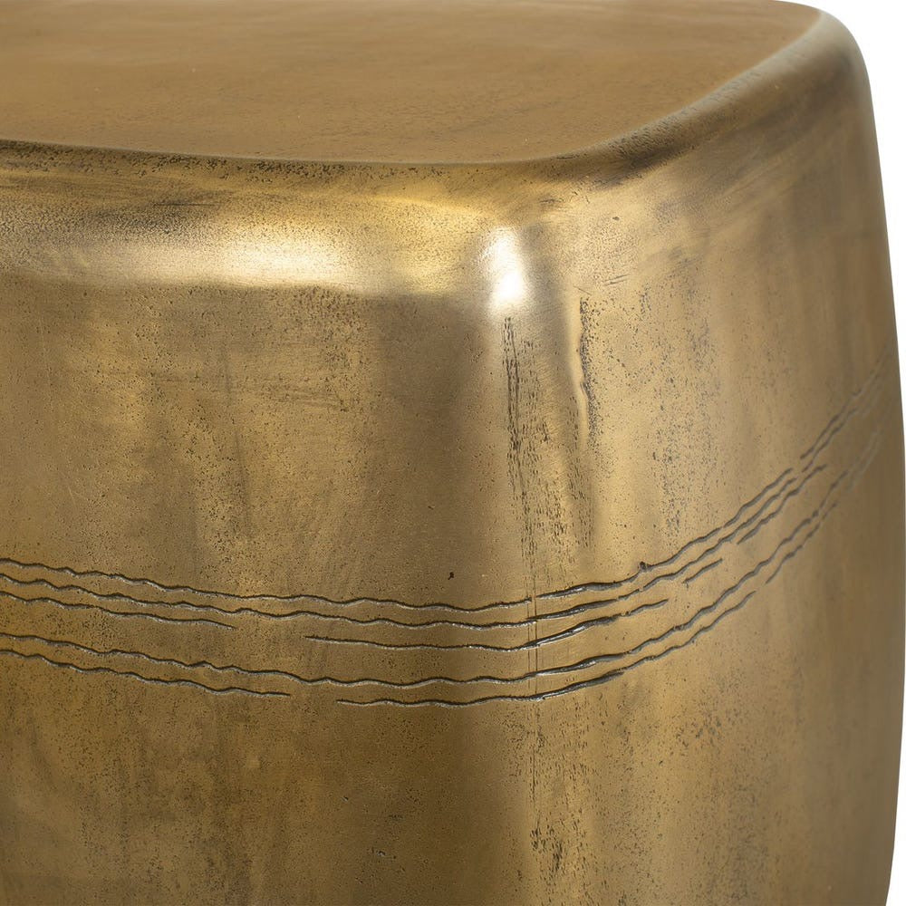 Close-up of a textured gold surface with engraved lines