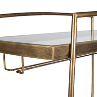 Gold metal bar cart close up with a glass top on a white background