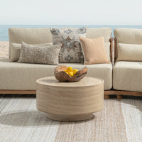 Beige sofa with decorative pillows and a beige stone coffee table in a living room setting.