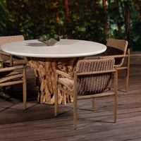 Round outdoor dining table with wicker chairs on a wooden deck