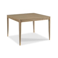 A square wooden table with a light oak finish and tapered legs, shown from a three-quarters angle on a white background.