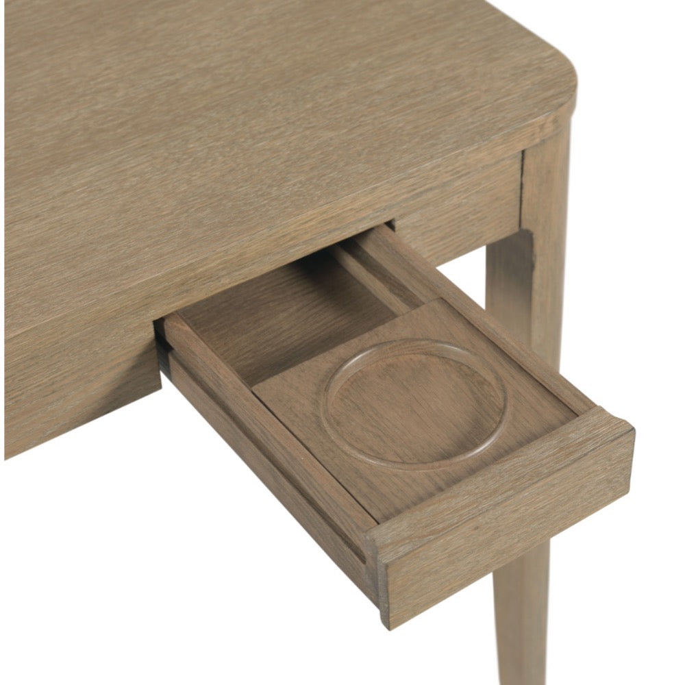 Close-up of a light oak wood table with an open drawer featuring a circular recessed cup holder, shown against a plain white background.