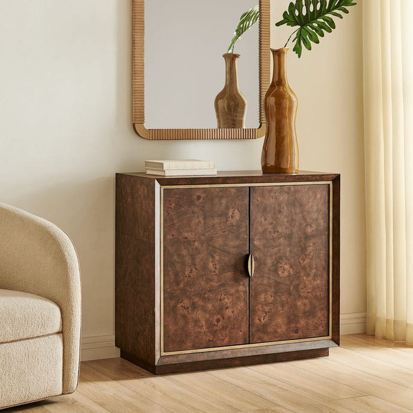 Wooden cabinet with two doors in a room with a mirror, books, and vases.