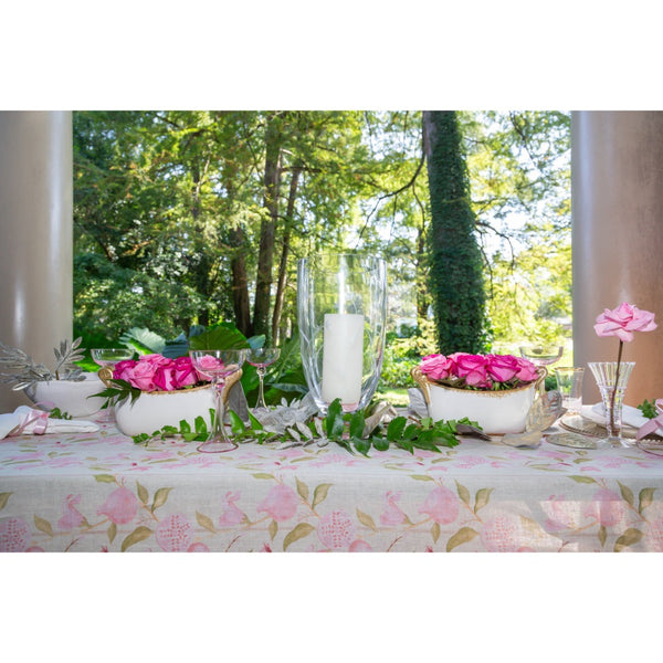 Decorative table setting with pink flowers and candles outdoors.