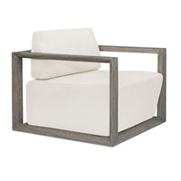 Uttermost Remsen Outdoor Lounge Chair with weathered gray frame and white cushions, shown at an angle.