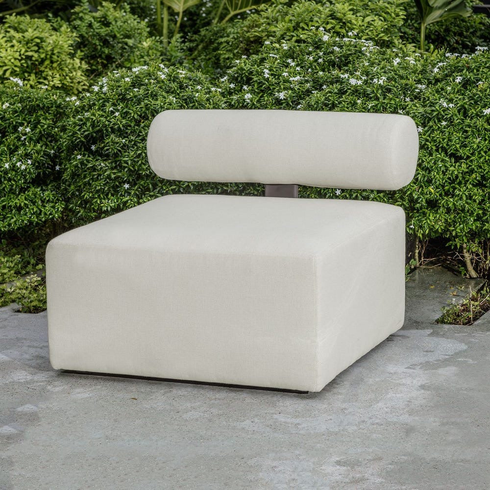 Modern beige chair with a backrest on a concrete surface with greenery in the background