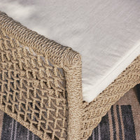 Close-up of a woven rattan corner with a white cushion