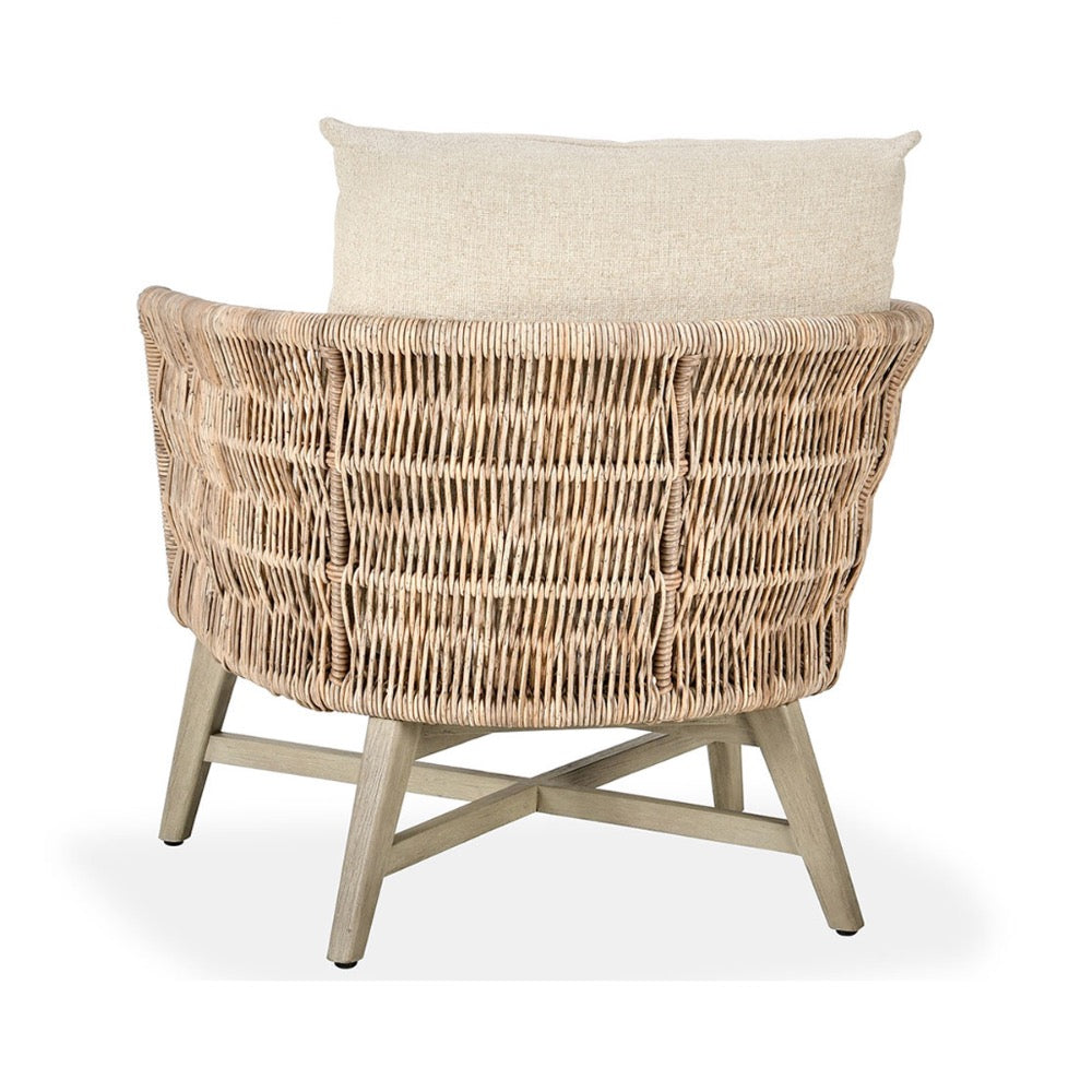 Wicker chair with a beige cushion on a white background