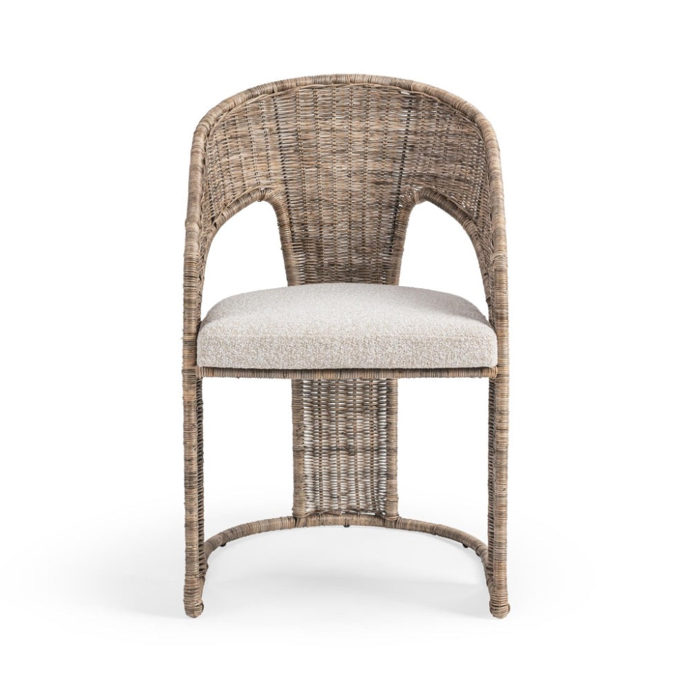 A single woven wicker dining chair with a curved backrest, cutout armholes, a light beige upholstered seat cushion, and curved legs, shown against a plain white background.